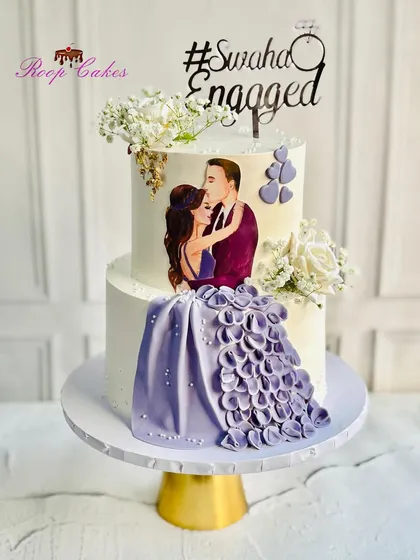 Two hearts, one promise. This stunning engagement cake features an edible portrait of the couple, with the bride's beautiful purple gown flowing down the side in a cascade of petals.