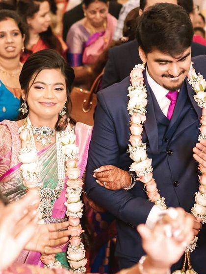 A candid, joyful moment as the couple enters their reception. The bride's makeup is radiant and her smile is infectious.