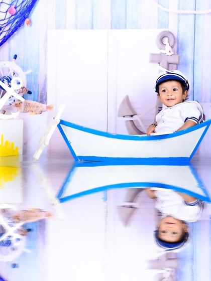 A little sailor in a boat prop with a water reflection effect, creating a dreamy, nautical scene.