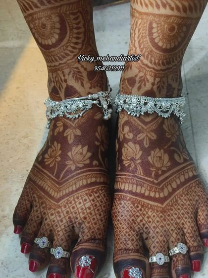 The rich, dark stain on this bride's feet is the result of our natural henna and proper aftercare. The design with lotus flowers and checks is beautifully highlighted.
