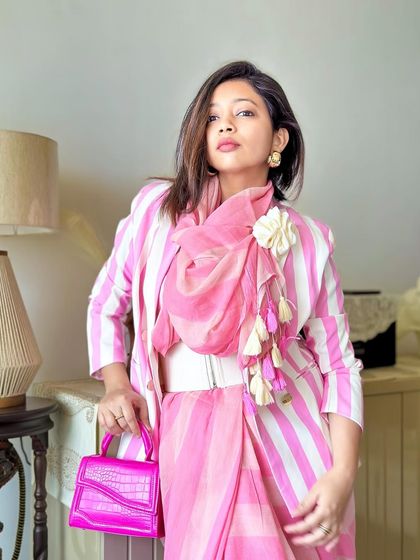 A confident pose showing how all the elements come together. The white belt breaks up the pink and defines the waist, while the rosette on the scarf adds a soft, feminine touch.