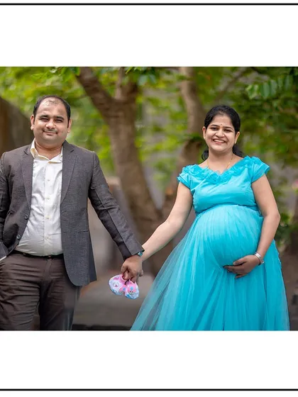 Holding hands and baby shoes, this couple's portrait is full of happiness and anticipation.