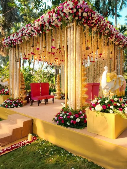 This outdoor mandap combines traditional elements with natural beauty. We used golden pillars, hanging floral strings, and elephant statues to create a sacred and picturesque ceremony setting.