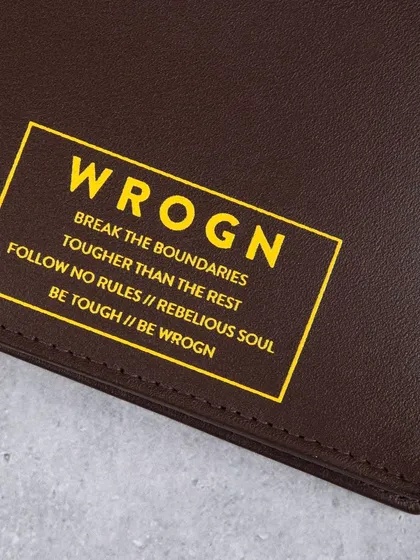 A close-up of the bold yellow branding on a dark brown 'WROGN' wallet.