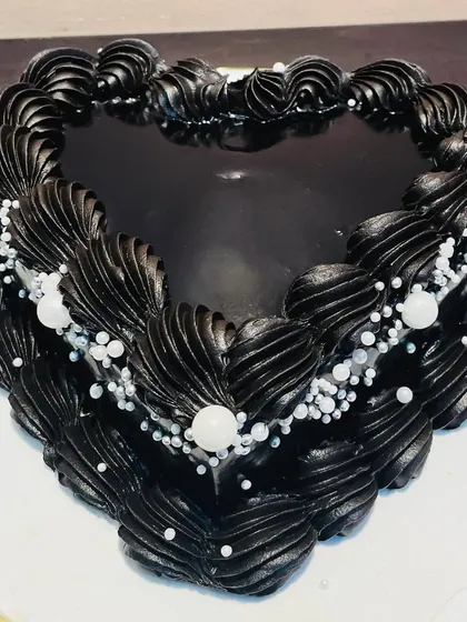 A vintage-style heart-shaped cake in dramatic black. Made with rich Belgian chocolate and decorated with delicate pearls, it's both elegant and delicious.
