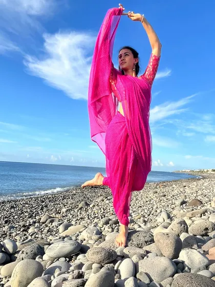 An energetic, one-legged dance pose on the beach, celebrating World Dance Day. This image captures my athleticism and control, showcasing my ability to hold strong, graceful poses.