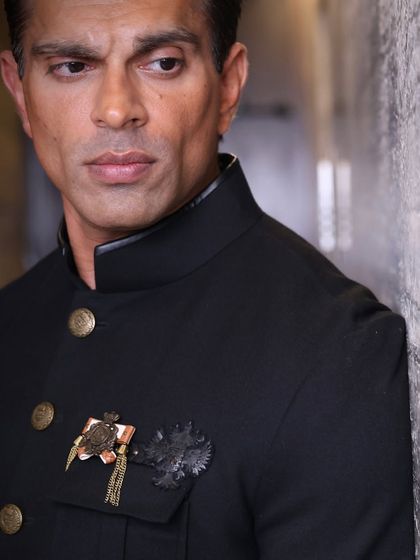 A detailed close-up on Karan's intense expression and the intricate details of his jacket. I focus on capturing both the person and the styling that defines their look.