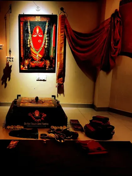 The Devi temple glowing in red light during a Purnima night. The atmosphere is intense and alive, charged with the energy of the moon and the divine feminine.