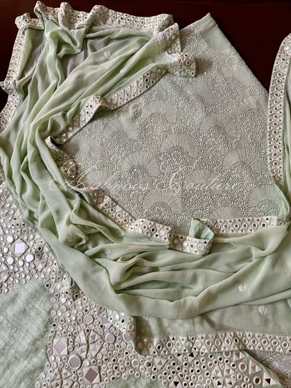 A draped view of the mint green suit, showing how the mirrorwork border of the dupatta catches the light.