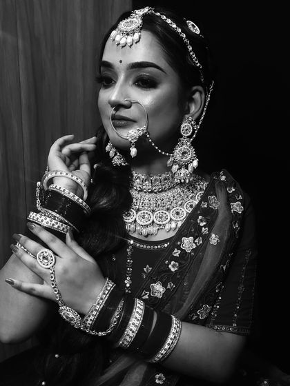 This monochrome shot highlights the traditional jewelry and the detailed hand adornments.