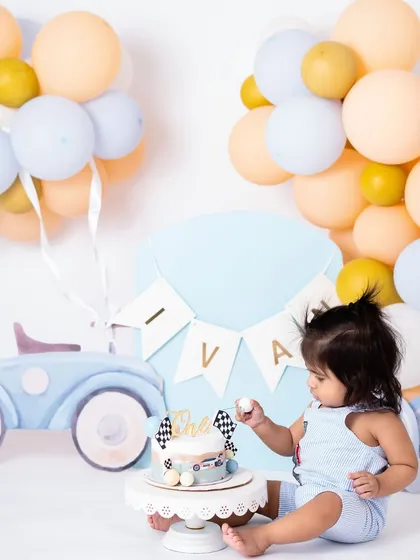 The full view of the car themed cake smash setup, with pastel balloons and a cute car cutout. I can customize themes to match your vision for your baby's first birthday photos.