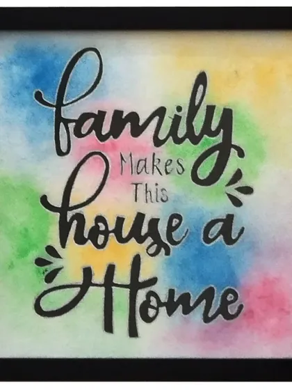 This piece celebrates the heart of any house. The quote "Family Makes This House a Home" is rendered in beautiful script over a vibrant, multi-color watercolor background, capturing the lively and colorful spirit of family life.