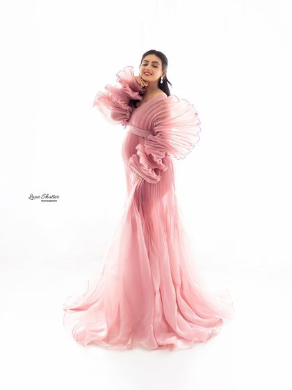 A joyful smile is the most beautiful accessory. This portrait captures the pure happiness of the mother-to-be, framed by the exquisite details of her couture gown.