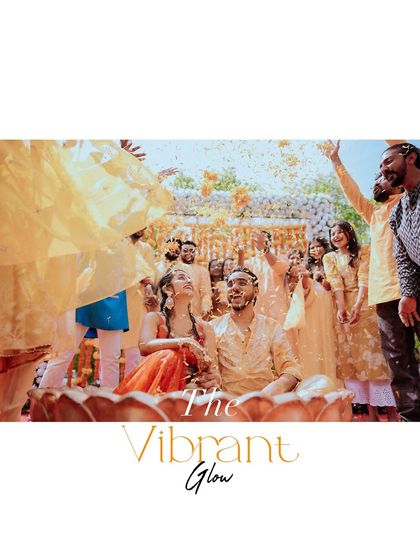 A vibrant photo of the couple being showered with flower petals during their Haldi ceremony. The image is full of energy, color, and happiness.