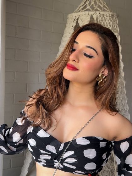 The winged liner and red lip combo is a classic for a reason. Here you can see how the makeup complements Uditi's features, creating a look that is both elegant and bold.