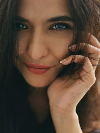 This is a bright, sun-drenched portrait that feels wild and free. The close-up on her smiling face, framed by her hair, captures a moment of pure joy and natural beauty, perfectly aligning with a lifestyle-focused photoshoot.