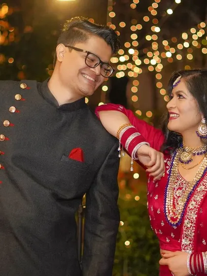 An evening pre-wedding shot with beautiful ambient lighting, capturing a sweet, shared smile between the couple.