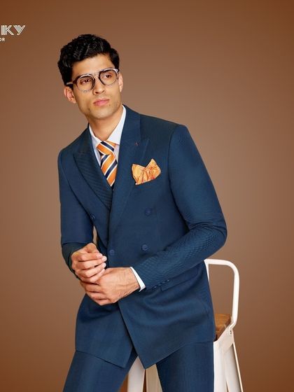 A navy blue double-breasted suit makes a statement of timeless elegance. We tailor our designs to ensure you look flawless for every unforgettable moment.