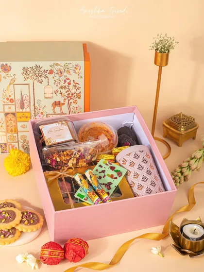This pastel pink Diwali hamper is filled with a mix of modern and traditional treats. The shot is bright and airy, giving it a fresh and contemporary feel.
