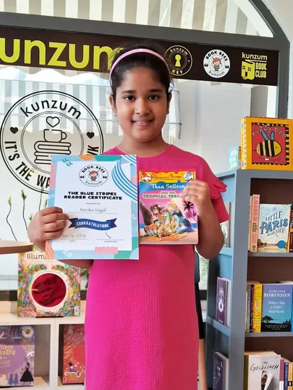 Another proud Blue Stripes reader. This young member has successfully completed her reading goal and is holding her certificate of achievement and a new book to start her next adventure.