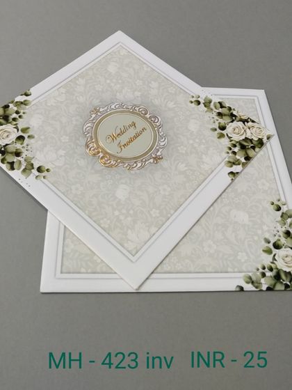 A simple white invitation adorned with corners of white roses. The design is clean and classic, with a central emblem for your names or initials.