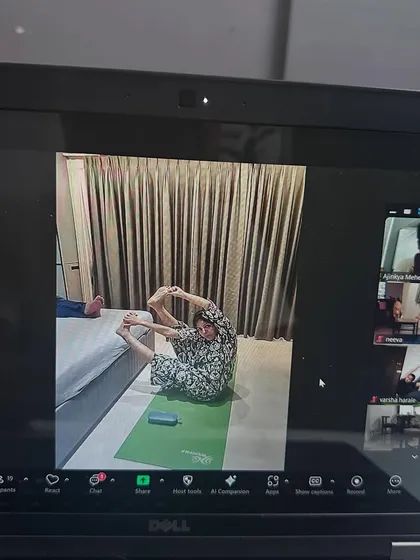 A student using her home furniture to assist in a pose. We learn to be creative with what we have in our online sessions.