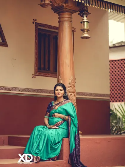 A contemplative solo portrait of the mother-to-be seated on the steps of a rustic home.