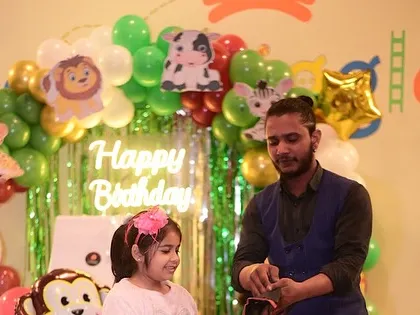 A magician performing a trick for the birthday girl during her jungle-themed party. It’s a great way to make the guest of honor feel extra special.
