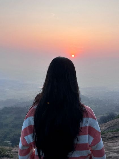 A trekker gazes at the beautiful colors of the sunrise at Uttari Betta.