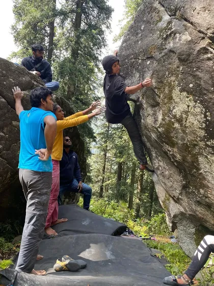 The 'Walk in the Park' boulder problem in Sethan is a classic. Here, you see our climbers working together, spotting and encouraging each other as they figure out the sequence of moves.