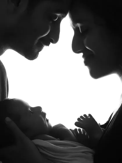 A new beginning. This artistic silhouette captures the moment a family of two becomes three. A beautiful, emotional portrait of parents adoring their newborn.