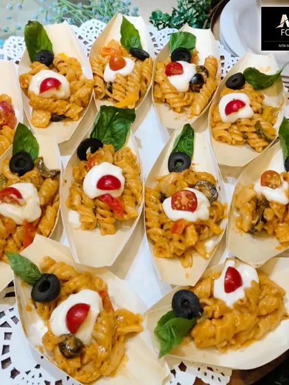 Individual portions of fusilli pasta in a creamy tomato sauce, served in eco-friendly boat-shaped dishes. This is a great option for pass-around service, allowing guests to enjoy pasta without a plate.