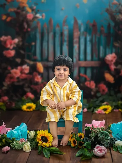 A sweet little boy in our enchanted garden. The vibrant flowers and rustic fence create a beautiful and imaginative setting.