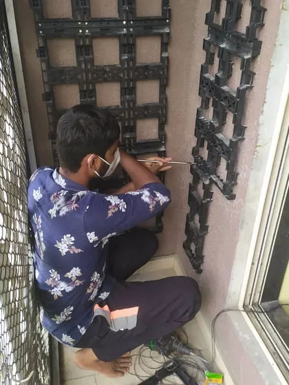 The foundation of a great vertical garden is a strong frame. Here, one of our technicians is installing the grid structure onto a balcony wall before the plant pockets are attached.