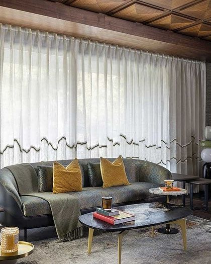 Another perspective of the family lounge, showing the elegant custom cabinetry and the soft, diffused light from the sheer curtains. The color palette is warm and earthy, promoting a sense of calm.