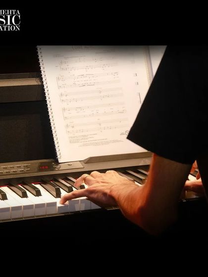 A close-up of a student's hands on the piano during a performance. This image captures the focus and dedication that goes into every note played on stage.