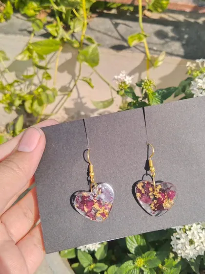 A pair of heart shaped earrings made with real preserved rose petals and gold flakes. Each pair is unique because they are made from real flowers.