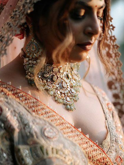 An artistic, moody shot focusing on the stunning details of her jewelry and the soft blend of her eye makeup.
