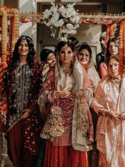 The bride's entrance under a 'phoolon ki chadar' held by her family, a cherished tradition.