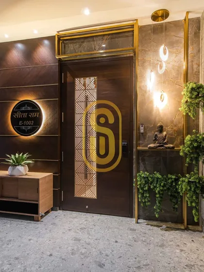 The entrance sets the tone for the entire home. We designed this welcoming foyer with a custom wooden door, an illuminated nameplate, and elegant pendant lighting, creating a memorable first impression.