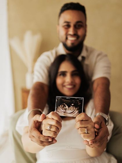 A creative shot focusing on the sonogram, with the happy parents-to-be blurred lovingly in the background.