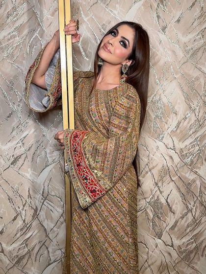 The full look. The dramatic makeup is the perfect complement to the intricate, colorful outfit.