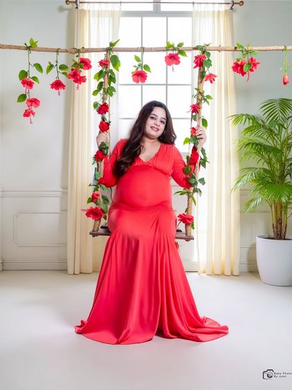 A classic studio shot on a floral swing against a bright window. This setup creates a light and airy feel, perfect for a timeless maternity portrait.