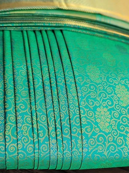 A detailed shot of the pleats on the turquoise saree.