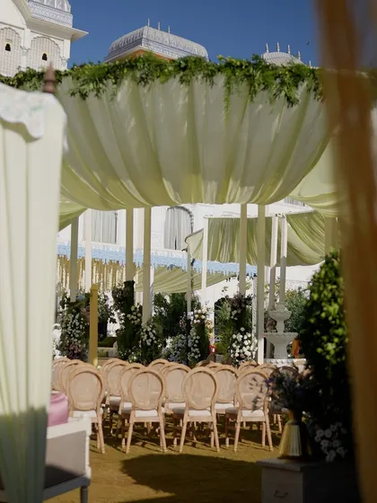 A glimpse of the ceremony setup through an opening in the draped canopy.