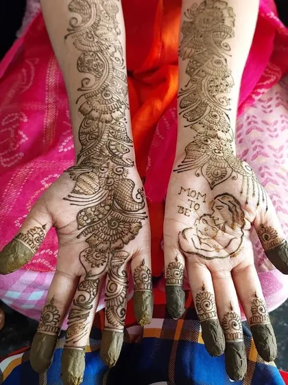 A special design for a mom-to-be, featuring a portrait of a mother and child. I love creating personalized mehendi like this for baby showers to make the day even more memorable.