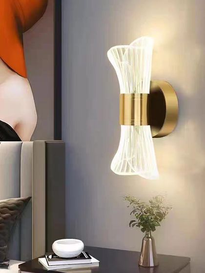 An hourglass-shaped wall sconce with fluted acrylic. This elegant design is perfect for placing on either side of a bed or a mirror.