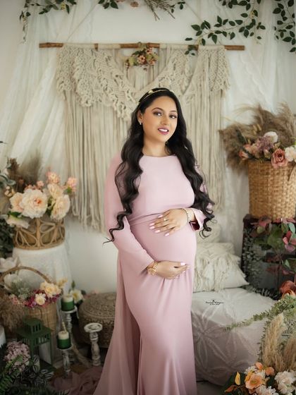 A classic and beautiful portrait of a mother-to-be. Her happy smile and the gentle way she holds her bump convey pure joy.