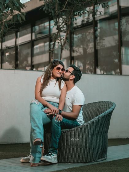 A sweet and tender moment in a modern outdoor setting. A gentle kiss on the cheek is a simple gesture that speaks volumes about their love.