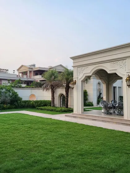 A stately classical gazebo stands as the centerpiece of a sprawling farmhouse lawn in Gurugram. This structure, with its elegant arches and intricate details, exemplifies our expertise in timeless design, creating a perfect setting for sophisticated outdoor gatherings.